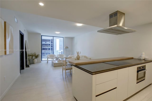 1000 Brickell Plz Unit 2705, Miami, FL 33131 - kitchen featuring island range hood, black electric cooktop, stainless steel oven, dark countertops, and floor to ceiling windows