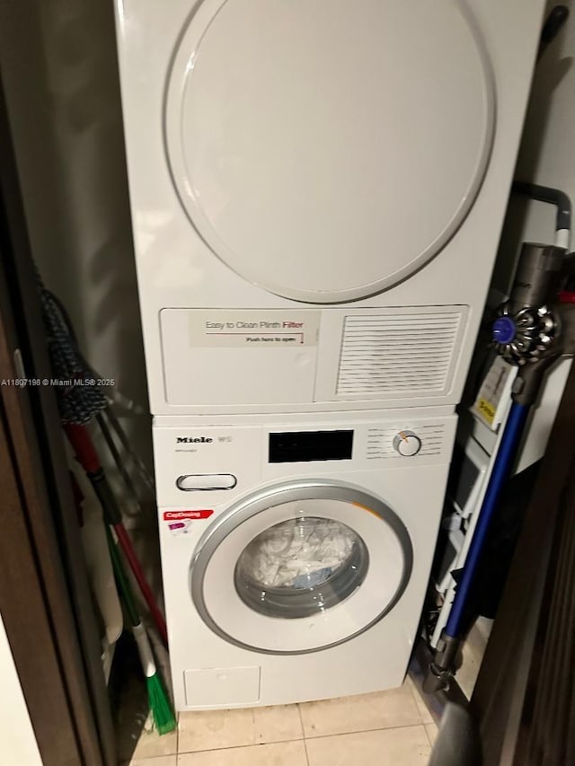 1000 Brickell Plz Unit 2705, Miami, FL 33131 - washroom featuring stacked washing machine and dryer and light tile patterned flooring