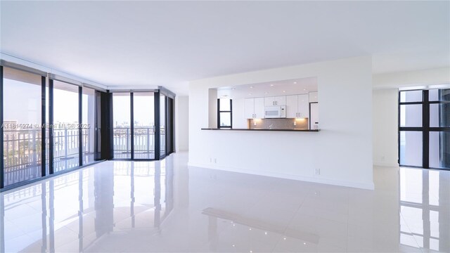 4000 Towerside Ter Unit 2201, Miami, FL 33138 - empty room with light tile patterned floors, a wall of windows, and baseboards