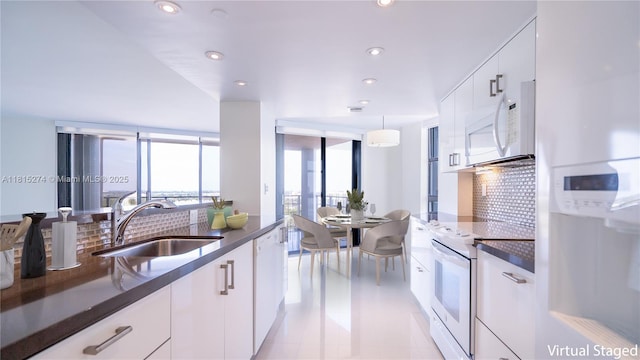 4000 Towerside Ter Unit 2201, Miami, FL 33138 - kitchen with a sink, white appliances, backsplash, white cabinets, and recessed lighting