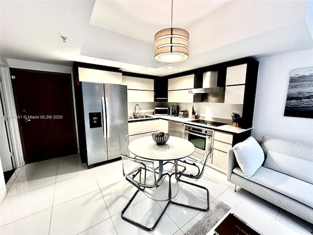 2155 Washington Ct Unit 110, Miami Beach, FL 33139 - kitchen featuring appliances with stainless steel finishes, wall chimney range hood, white cabinetry, a sink, and recessed lighting