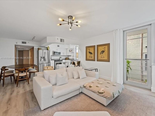 1532 Drexel Ave Unit 204, Miami Beach, FL 33139 - living room with a chandelier, healthy amount of natural light, and light wood finished floors