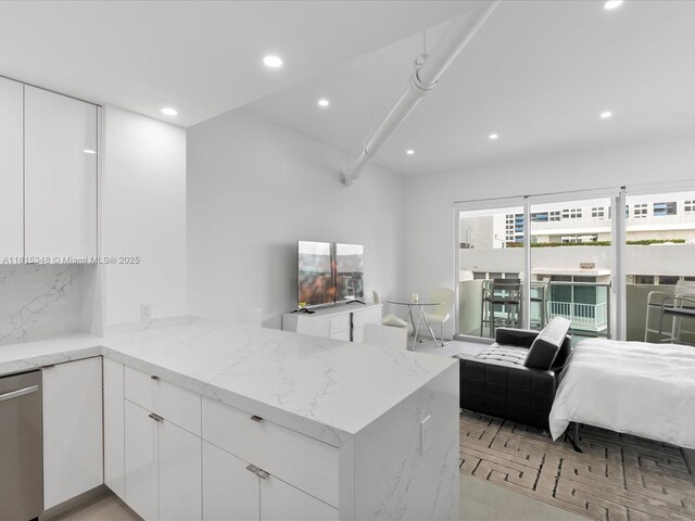 1200 W Ave Unit Ph24, Miami Beach, FL 33139 - kitchen with modern cabinets, recessed lighting, light stone counters, and a peninsula
