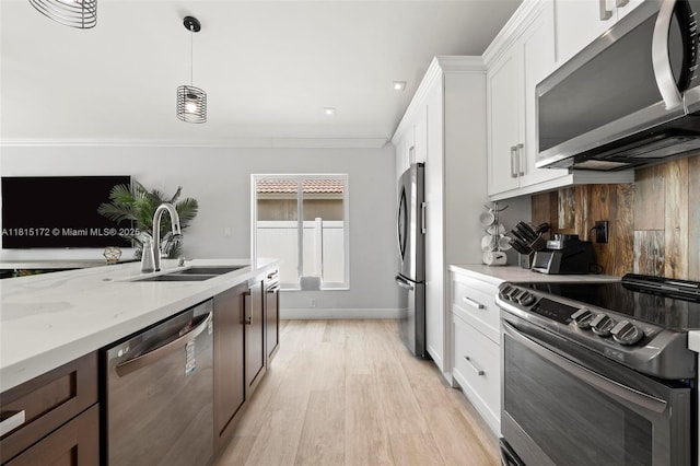 14420 NW 16th St, Pembroke Pines, FL 33028 - kitchen with stainless steel appliances, light wood-type flooring, white cabinetry, pendant lighting, and light stone countertops