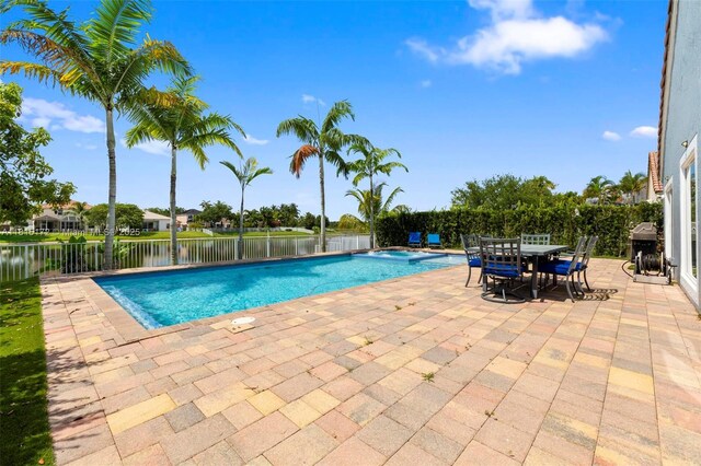 14420 NW 16th St, Pembroke Pines, FL 33028 - view of pool featuring a patio area, a pool with connected hot tub, outdoor dining space, grilling area, and a water view