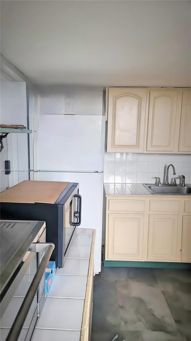 16850 S Glades Dr Unit 8G, North Miami Beach, FL 33162 - kitchen featuring a sink, cream cabinetry, and backsplash