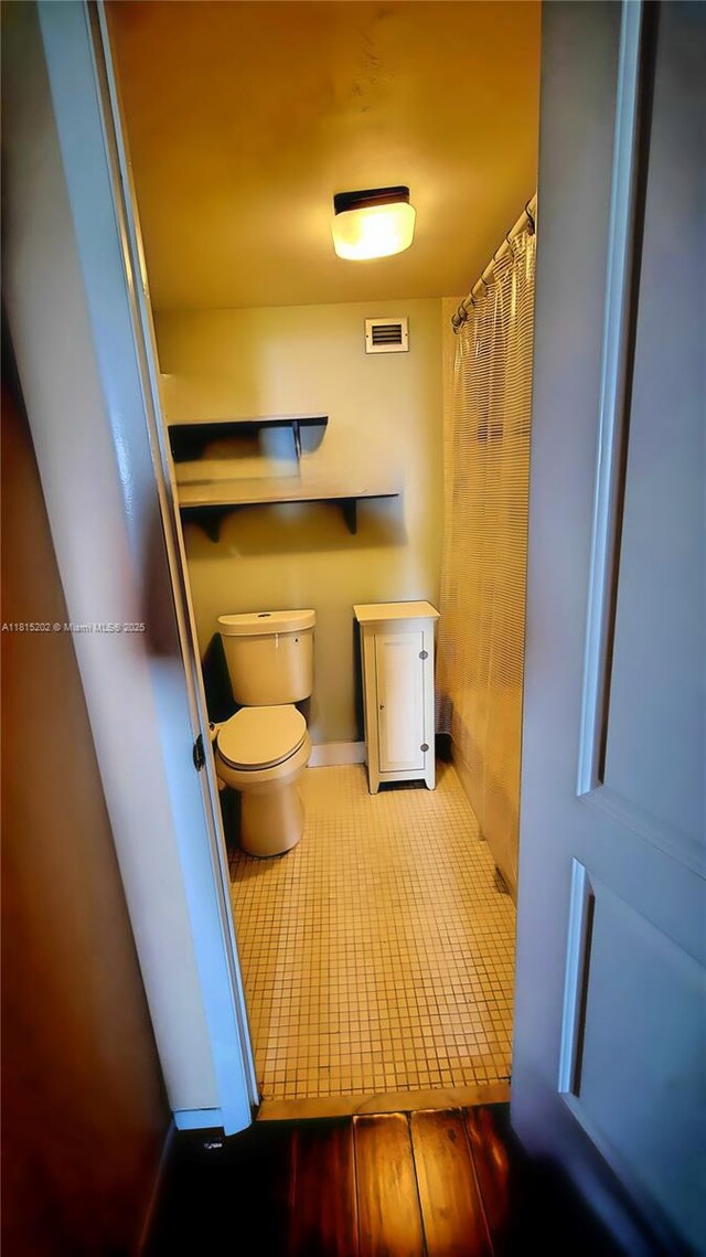 16850 S Glades Dr Unit 8G, North Miami Beach, FL 33162 - bathroom with toilet, tile patterned flooring, and baseboards