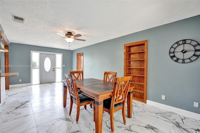 2398 SE Bordeaux Ct, Port St Lucie, FL 34952 - dining space with light marble finish floors, a ceiling fan, a textured ceiling, and baseboards