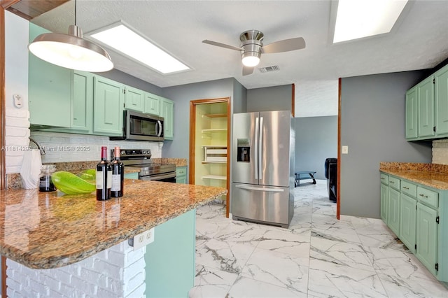 2398 SE Bordeaux Ct, Port St Lucie, FL 34952 - kitchen with stainless steel appliances, green cabinets, a peninsula, and ceiling fan