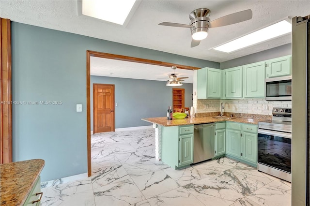 2398 SE Bordeaux Ct, Port St Lucie, FL 34952 - kitchen featuring stainless steel appliances, a sink, ceiling fan, light marble finish flooring, and a peninsula