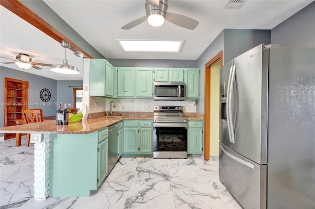 2398 SE Bordeaux Ct, Port St Lucie, FL 34952 - kitchen featuring stainless steel appliances, a ceiling fan, green cabinetry, a peninsula, and a textured ceiling