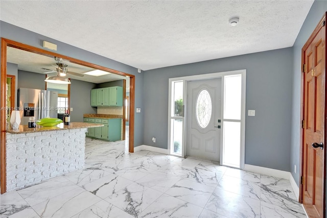 2398 SE Bordeaux Ct, Port St Lucie, FL 34952 - entrance foyer with baseboards, a textured ceiling, light marble finish flooring, and a ceiling fan