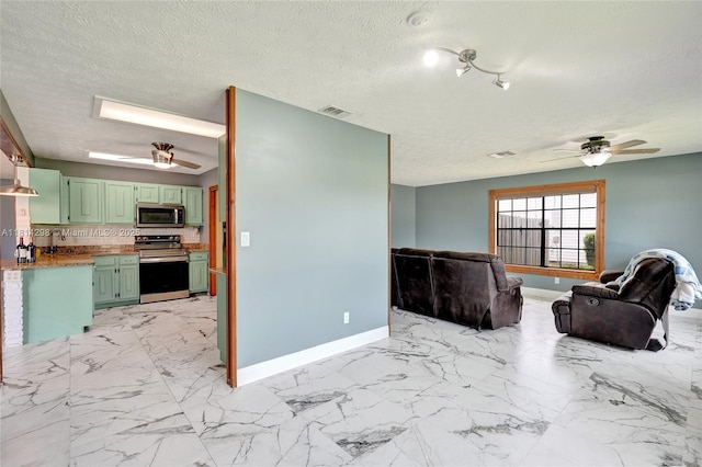 2398 SE Bordeaux Ct, Port St Lucie, FL 34952 - unfurnished living room with ceiling fan, baseboards, a sink, light marble finish floors, and a textured ceiling
