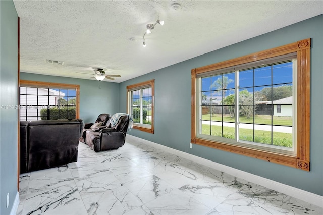 2398 SE Bordeaux Ct, Port St Lucie, FL 34952 - sitting room with baseboards, ceiling fan, marble finish floors, and a textured ceiling