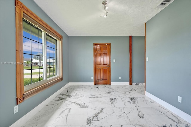 2398 SE Bordeaux Ct, Port St Lucie, FL 34952 - empty room with baseboards, marble finish flooring, and a textured ceiling