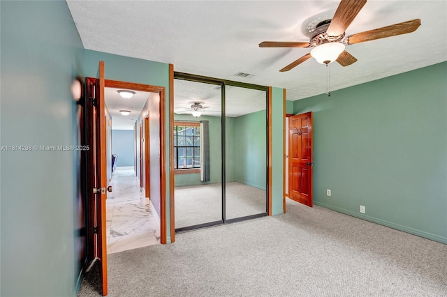 2398 SE Bordeaux Ct, Port St Lucie, FL 34952 - unfurnished bedroom with a closet, baseboards, carpet flooring, a ceiling fan, and a textured ceiling