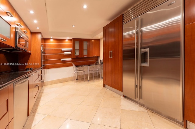 10205 Collins Ave Unit 401, Bal Harbour, FL 33154 - kitchen featuring stainless steel appliances, recessed lighting, glass insert cabinets, light tile patterned flooring, and dark stone countertops