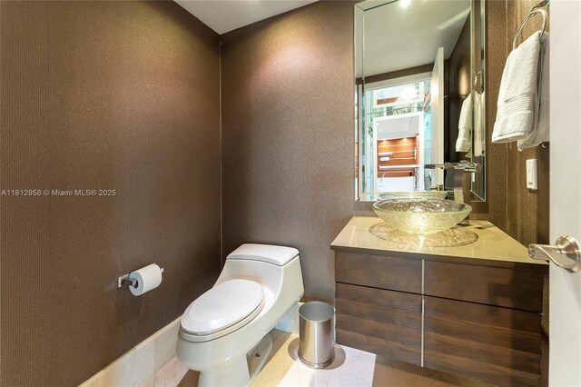 10205 Collins Ave Unit 401, Bal Harbour, FL 33154 - bathroom featuring vanity, toilet, and a textured wall