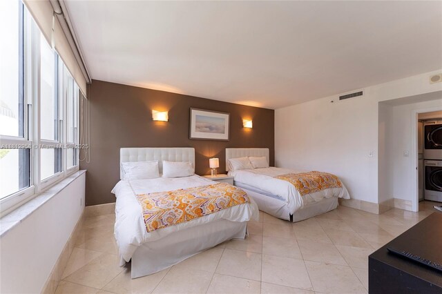 10205 Collins Ave Unit 401, Bal Harbour, FL 33154 - bedroom with stacked washer / drying machine and baseboards