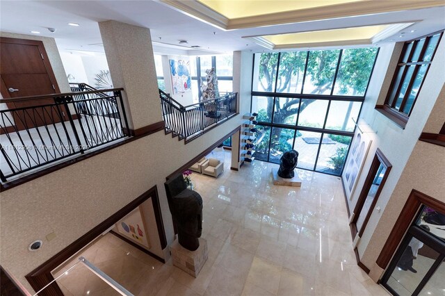 10205 Collins Ave Unit 401, Bal Harbour, FL 33154 - corridor featuring floor to ceiling windows, an upstairs landing, a tray ceiling, and recessed lighting