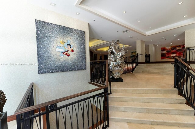 10205 Collins Ave Unit 401, Bal Harbour, FL 33154 - stairway featuring a tray ceiling and recessed lighting