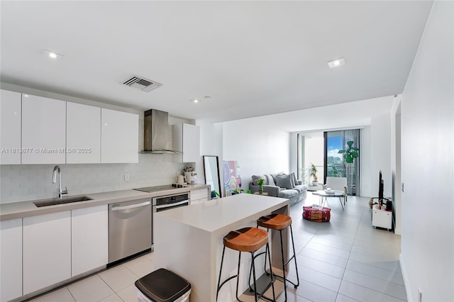 1600 NE 1st Ave Unit 1112, Miami, FL 33132 - kitchen with wall chimney range hood, stainless steel appliances, a sink, a breakfast bar area, and backsplash
