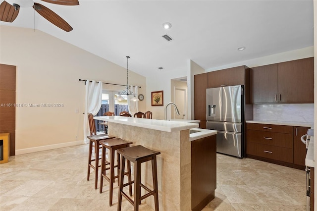 875 NW 108th Ln, Coral Springs, FL 33071 - kitchen with stainless steel refrigerator with ice dispenser, a breakfast bar area, light countertops, ceiling fan, and hanging light fixtures