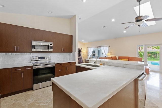 875 NW 108th Ln, Coral Springs, FL 33071 - kitchen featuring stainless steel appliances, a sink, tasteful backsplash, light countertops, and vaulted ceiling