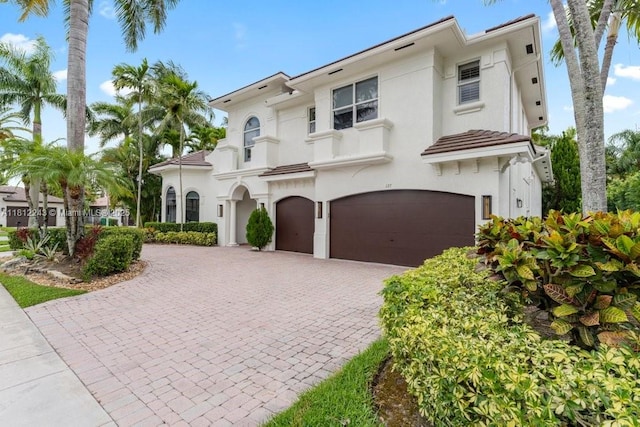 127 Swan Ave, Plantation, FL 33324 - mediterranean / spanish house featuring stucco siding, an attached garage, and decorative driveway