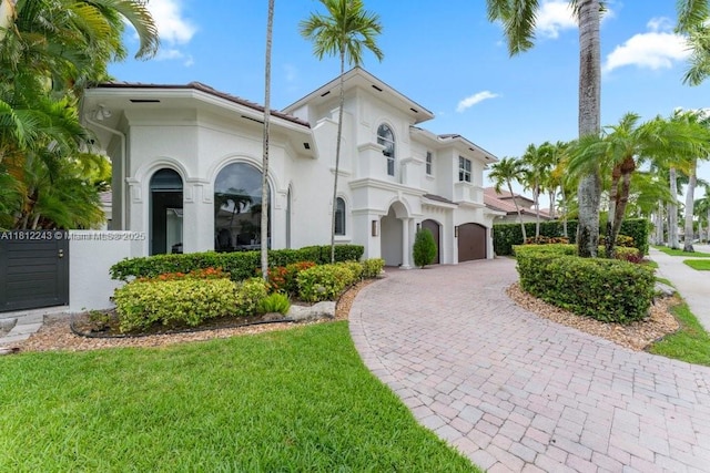 127 Swan Ave, Plantation, FL 33324 - mediterranean / spanish-style house featuring curved driveway, stucco siding, and a front yard