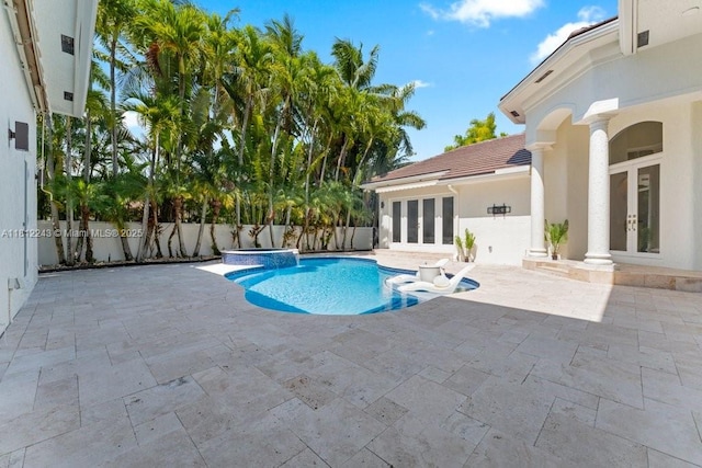 127 Swan Ave, Plantation, FL 33324 - view of swimming pool featuring french doors, a pool with connected hot tub, a patio, and a fenced backyard