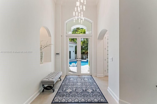 127 Swan Ave, Plantation, FL 33324 - entrance foyer with arched walkways, french doors, a high ceiling, baseboards, and a chandelier