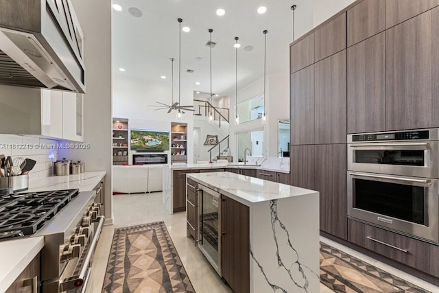 127 Swan Ave, Plantation, FL 33324 - kitchen featuring modern cabinets, appliances with stainless steel finishes, range hood, ceiling fan, and a sink