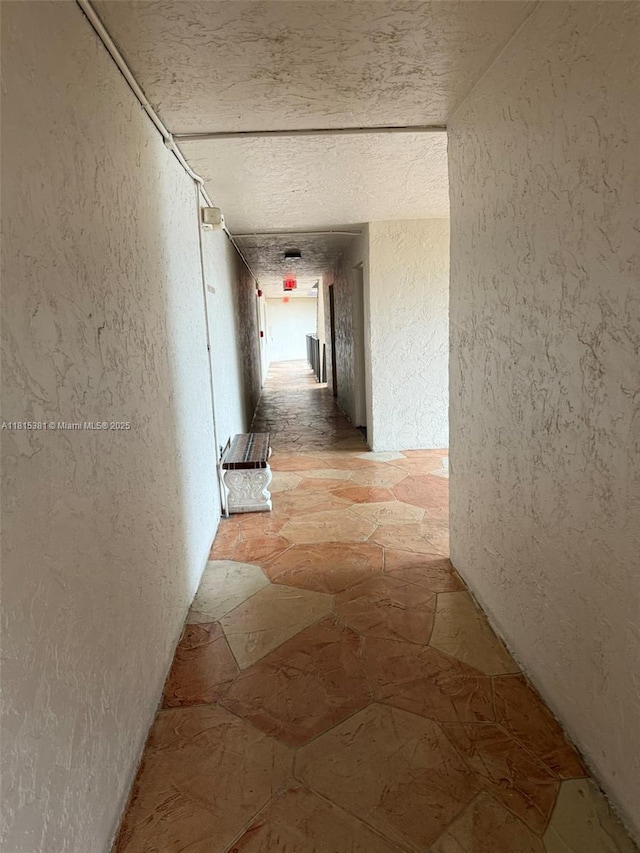 7850 W Mcnab Rd Unit 212, Tamarac, FL 33321 - hallway featuring a textured wall and light stone finish flooring