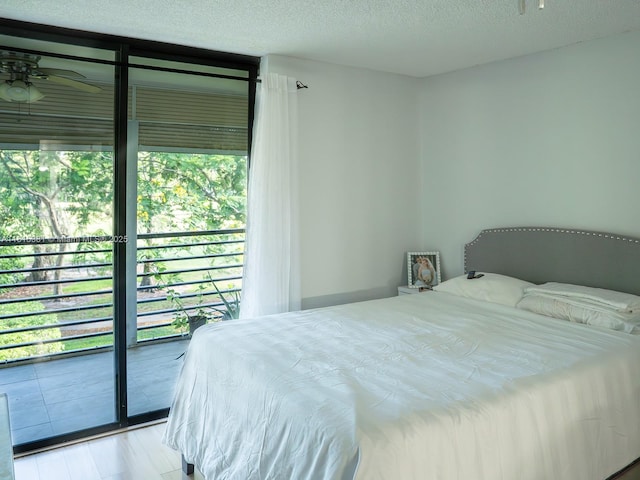 7850 W Mcnab Rd Unit 212, Tamarac, FL 33321 - bedroom with access to outside, wood finished floors, a wall of windows, and a textured ceiling