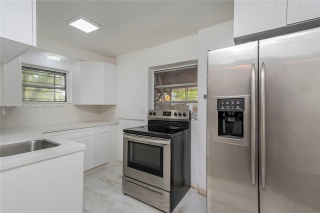 2210 NW 154th St, Miami Gardens, FL 33054 - kitchen with appliances with stainless steel finishes, white cabinetry, light countertops, and light marble finish flooring