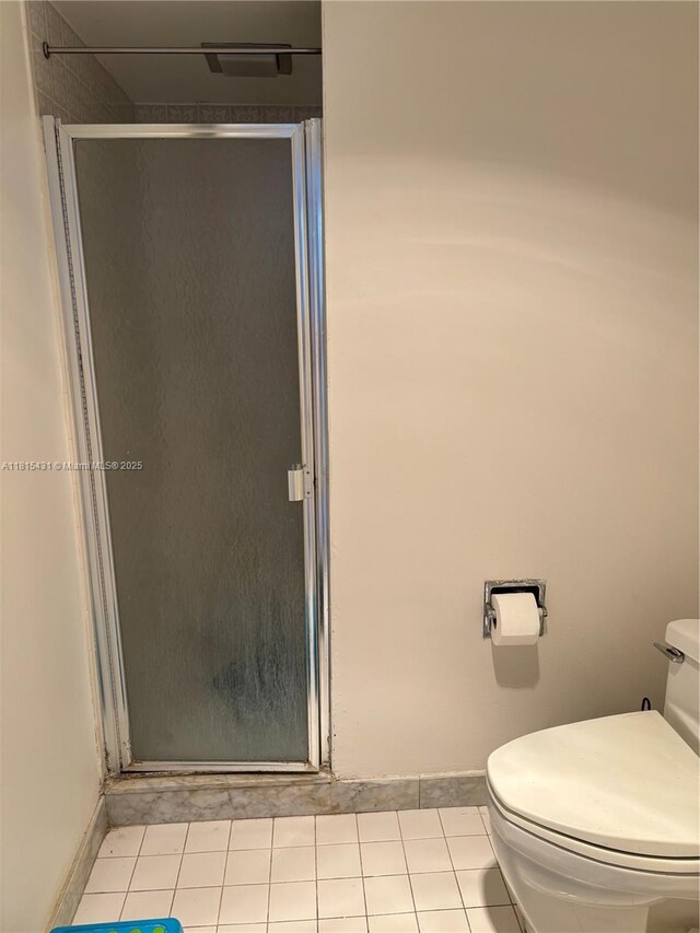 1865 S Ocean Dr Unit 11I, Hallandale Beach, FL 33009 - bathroom featuring a stall shower, toilet, tile patterned flooring, and baseboards