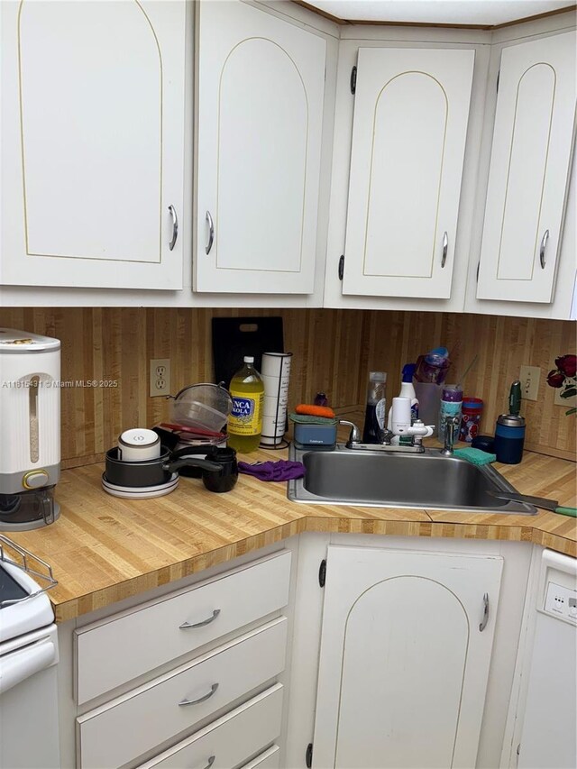 1865 S Ocean Dr Unit 11I, Hallandale Beach, FL 33009 - kitchen featuring a sink, wood walls, white cabinets, and butcher block countertops