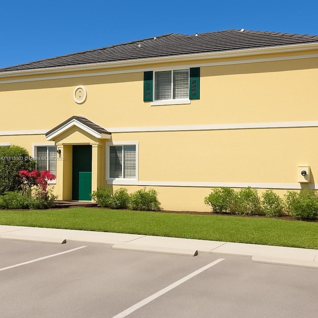 7702 Paddock Pl, Davie, FL 33328 - view of front of home with uncovered parking, stucco siding, and a front yard