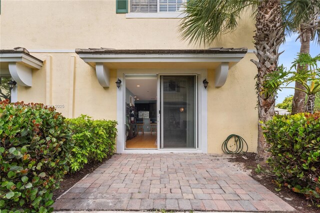 7702 Paddock Pl, Davie, FL 33328 - doorway to property featuring stucco siding and a patio area