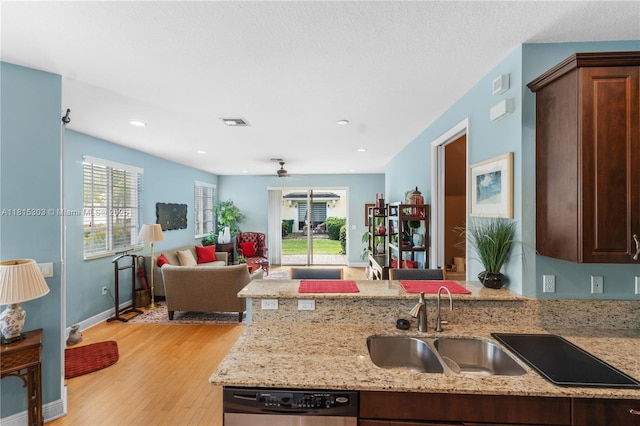 7702 Paddock Pl, Davie, FL 33328 - kitchen with stainless steel dishwasher, a peninsula, open floor plan, light wood-type flooring, and light stone counters