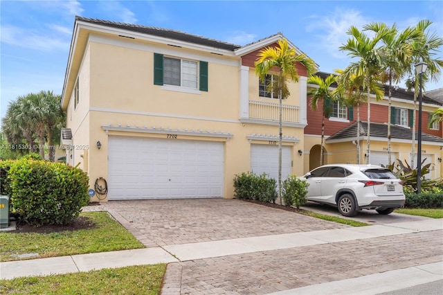 7702 Paddock Pl, Davie, FL 33328 - townhome / multi-family property featuring an attached garage, stucco siding, and decorative driveway