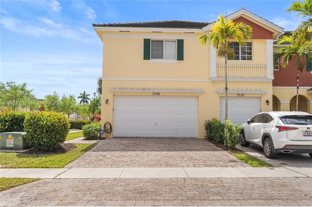 7702 Paddock Pl, Davie, FL 33328 - view of front facade featuring a garage, stucco siding, and decorative driveway