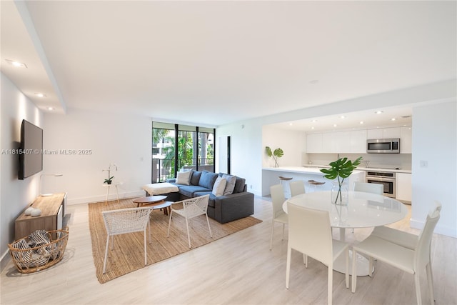 181 Crandon Blvd Unit 306, Key Biscayne, FL 33149 - living room featuring light wood finished floors, baseboards, a wall of windows, and recessed lighting