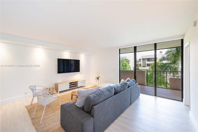 181 Crandon Blvd Unit 306, Key Biscayne, FL 33149 - living room featuring light wood-style floors, a wall of windows, and baseboards