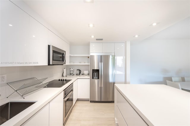 181 Crandon Blvd Unit 306, Key Biscayne, FL 33149 - kitchen featuring appliances with stainless steel finishes, modern cabinets, open shelves, white cabinets, and light countertops