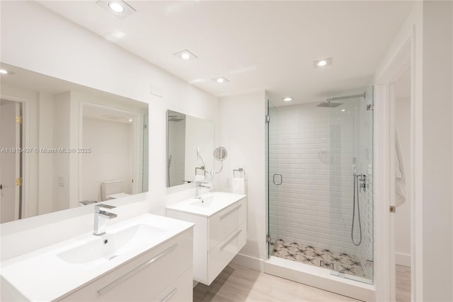 181 Crandon Blvd Unit 306, Key Biscayne, FL 33149 - bathroom featuring a stall shower, two vanities, toilet, recessed lighting, and wood finished floors
