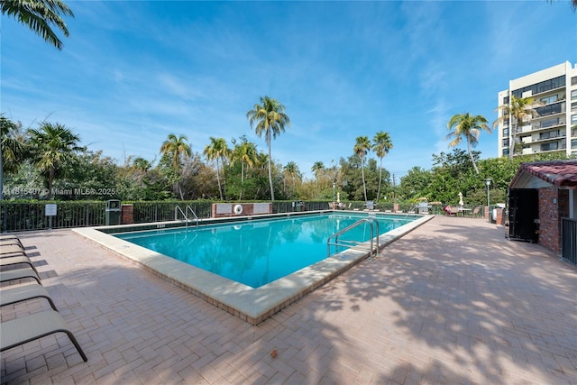 181 Crandon Blvd Unit 306, Key Biscayne, FL 33149 - community pool with view of wooded area and a patio