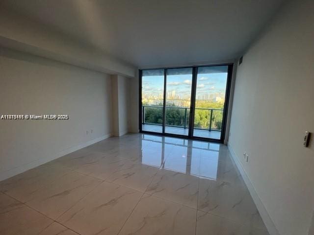 16385 Biscayne Blvd Unit 820, North Miami Beach, FL 33160 - spare room with a wall of windows, baseboards, and light marble finish floors