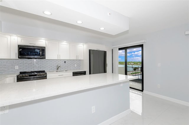 1201 S Ocean Dr Unit 610N, Hollywood, FL 33019 - kitchen with stainless steel appliances, a sink, backsplash, white cabinets, and light stone countertops